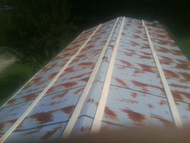 Rusted metal roof panels with new wood purlins before replacement — Storm Damage Roof Repair in Grissom Arb by Roofing Brothers