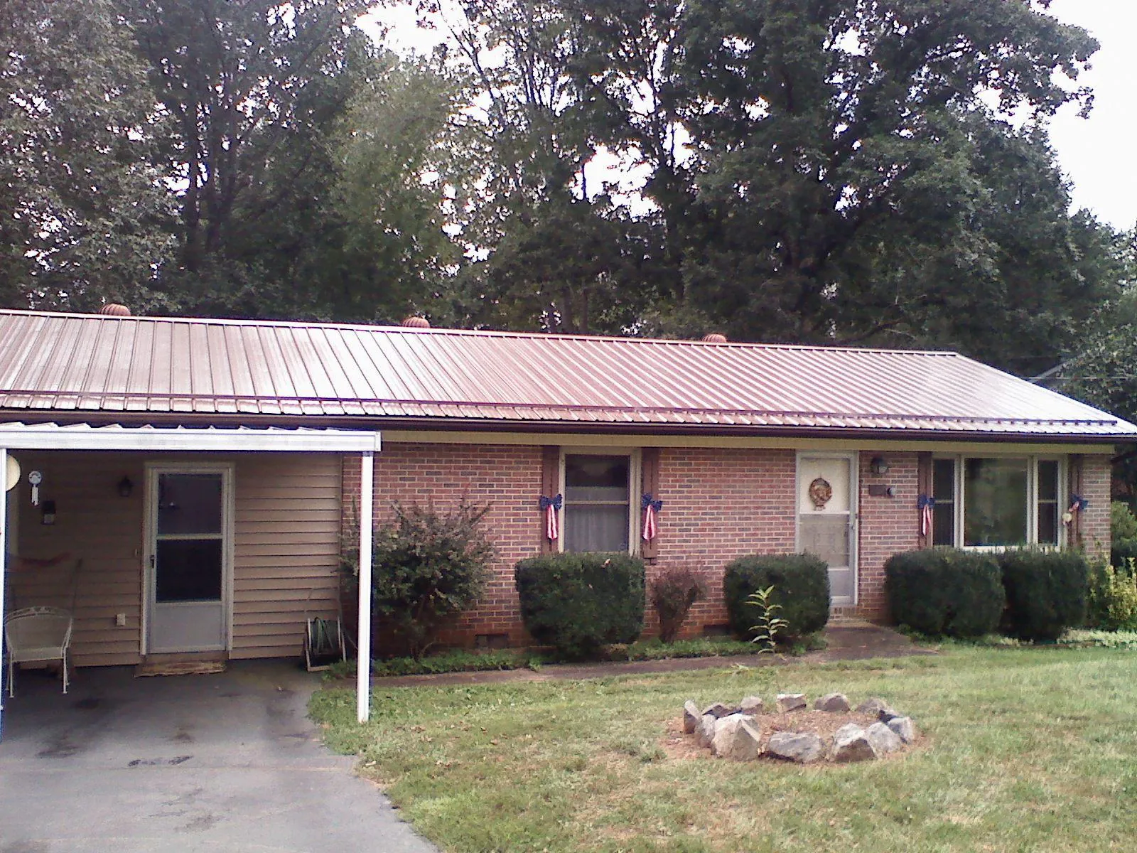 Bronze metal roof and carport on a brick ranch home — Roof Repair work by our crew in Grissom Arb