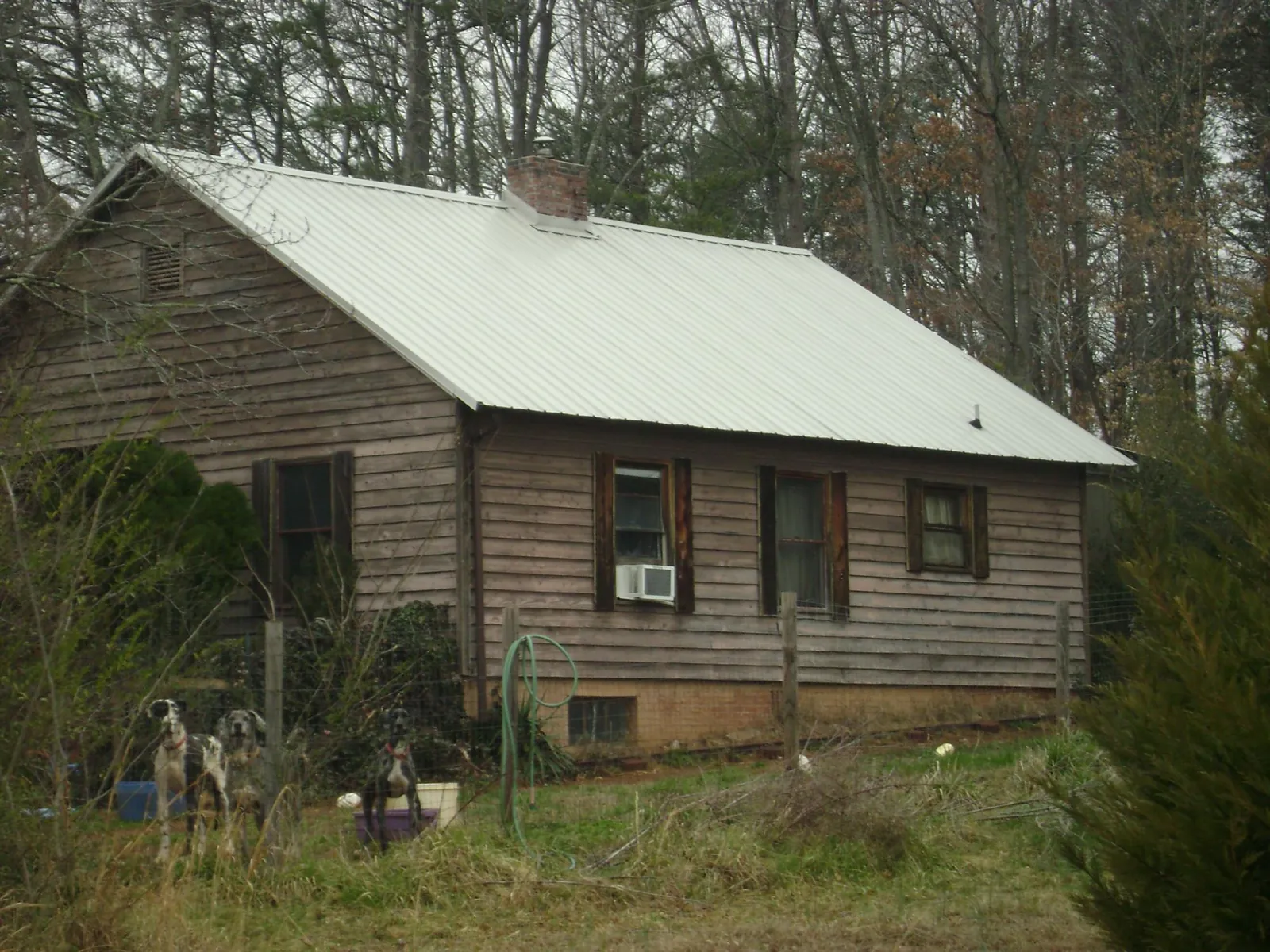 White metal roof on an old wood sided farmhouse, from a Metal Roof Installation job in Grissom Arb
